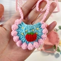 Dettaglio di un bavaglino per bambole all'uncinetto blu con fragola e pois rosa - Bavaglino / Bavaglino Blu E Rosa