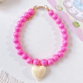 Detailed shot of pink beaded pet necklace with iridescent heart pendant and gold clasp - Rose Red Necklace
