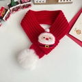 Detail van rode gebreide kerstsjaal met kerstman-patch en een zachte witte pomponbal - S / Kerstman Slabbetje