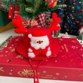 Kerstmuts voor huisdieren met rode geweien en een pluchen Kerstman-decoratie op doos - Kerstman Muts Patroon