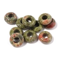 Macro view of natural unakite stone donut beads with polished finish for DIY jewelry - 10mm / Unakite