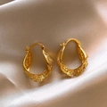 Vue détaillée de boucles d'oreilles créoles dorées en filigrane sur du satin champagne - Boucle d'oreille / Or