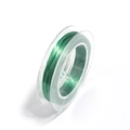 Macro shot of green elastic crystal beading cord on translucent spool for DIY jewelry - Green