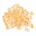 Close-up of transparent acrylic round alphabet beads with golden A-Z letters for DIY crafts - 100 Pcs/Pack / Transparent Yellow (Mixed)