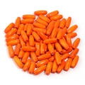 Macro shot of polished orange oval capsule wood beads with glossy finish and central hole - Orange
