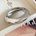 Vista macro di un bracciale rigido in metallo argento lucido dal design irregolare - Stile design a torsione irregolare (70#) / Argento