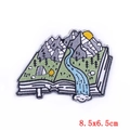 Macro detail of adventure nature embroidery patch with book landscape and sun, 8.5x6.5cm - 8.5x6.5cm
