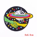 Detailed view of 8x6.8cm round space embroidery patch with planet and alien hand motif - Alien Contact Style (PE6069CT)