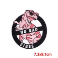 Vista macro de parche bordado de dinosaurio rosa con texto No Bad Vibes y reverso adhesivo - Estilo De Dinosaurio Con Gafas De Sol Rosa (PE8688CT)