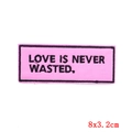 Pink rectangular patch with Love Is Never Wasted embroidery and black stitched border - PE6469CT