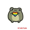 Détail d'un écusson brodé grenouille de 4,1x4,1cm tenant un cœur arc-en-ciel coloré - Style Grenouille Vert Haricot Avec Cœur (PE8716CT)