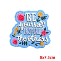 Macro view of blue embroidery patch with floral motifs and inspiring lettering - Inspirational Quote Floral Style (PE7109CT)