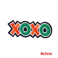 Detailed embroidery of XOXO letter patch with orange and green stitching on white background - XOXO Letter Style (PE9606CT)