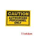 Macro detail of Caution Authorized Personnel Only embroidered patch with yellow border - Authorized Personnel Only Warning (PE8751CT)
