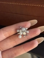 Dettaglio ravvicinato di un ear cuff floreale argento con perle bianche e zirconi lucidi - Grappolo di Fiori / Pezzo Singolo / Argento