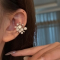 Primo piano di un elegante ear cuff a fiore con zirconi e perle indossato sull'orecchio - Clip per osso dell'orecchio (Singolo) / Argento