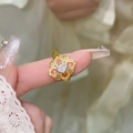 Gros plan détaillé d'une bague ouverte dorée vintage avec incrustation de zircon et texture - Fleur à Quatre Pétales Creuse Dorée (Plaqué Or Véritable)