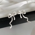 Detaillierte Nahaufnahme eleganter mattsilberner Schleifen-Ohrklemmen auf Box. - Ohrklemmen / Silber