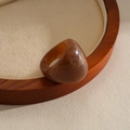 Detail of a retro amber resin marbled ring on a circular wooden tray. - Dark Coffee