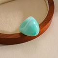 Detailed view of a vintage-style mint green marbled resin ring on a wooden tray. - Green