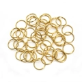 Macro shot of polished gold-plated closed jump rings for DIY jewelry making and connecting - Gold