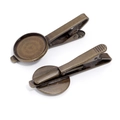 Detailed macro view of vintage bronze tie clip bases with round cabochon trays - Bronze
