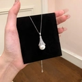 Detailed close-up view of elegant zircon bell-capped pearl pendant on black display card - Silver