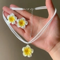 Detailed view of the white and yellow frangipani flower necklace and earrings jewelry set - Necklace and Earring Set / White