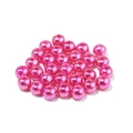 Macro shot of bright pink ABS faux pearls with pre-drilled holes for DIY jewelry making - Rose Red