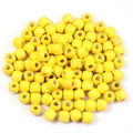 Détail macro de perles cylindriques en bois d'érable jaune avec finition laquée lisse - Jaune