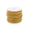 Close-up of golden metal ball chain roll on white plastic spool for DIY jewelry making - 1.5mm / Gold