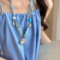 Detailed macro view of sea shell and starfish charms on a blue seaside fabric necklace - 3# Necklace-Blue-Conch