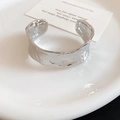 Close-up detail of a wide silver open cuff bracelet with unique hammered texture design - Hammered Texture Shape (83#) / Silver