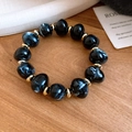 Detailansicht eines böhmischen Armbands mit schwarzen Marmorperlen und Goldakzenten - Armband / Schwarz