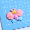 Ciondolo a farfalla in resina rosa e blu con faccina sorridente per decorazioni DIY - Design a Farfalla