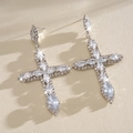 Close-up detail of sparkling marquise zircon cross earrings with silver needles. - Stud Pin Style / Silver