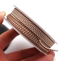Detailed view of 1.5mm brown and white dragon pattern braided cord on a plastic spool - Brown White Style