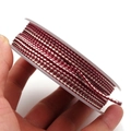Macro detail of 1.5mm two-tone dragon pattern woven cord for DIY jewelry on a clear spool - Approximately 1.2mm / Wine Red Cream
