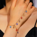 Detailed view of the gold-plated Evil Eye and Hamsa hand harness bracelet on a hand - Evil Eye Hamsa Hand Ring-Linked Bracelet (X286) / Gold (X286)