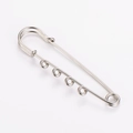 Detailed macro view of a silver-toned four-hole safety pin brooch for DIY jewelry crafting - Silver