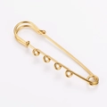 Detailed macro view of an 18k gold plated 4-hole safety pin for creative DIY jewelry. - Gold