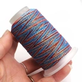 Macro detail of multi-colored wax thread roll held by hand for DIY jewelry crafting - 6-Strand / C57 (Blue Red Gold)