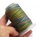 Macro detail of multi-color gradient waxed thread on a white spool for DIY crafting - 6-Strand / C329 (Blue Green Pink Gold)