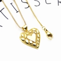 Macro-opname van gouden hart hanger met matte textuur en karabijnsluiting aan box ketting - 5+Halsketting (Relief Hart Kettingset)