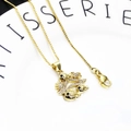Close-up of gold plated twin fish pendant with pavé zircon details on box chain necklace - Seahorse and Coconut Tree Necklace