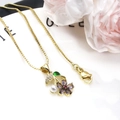 Macro detail of gold flower pendant with purple stones, white pearl and green enamel leaf - Purple Pendant With Necklace