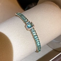 Nahaufnahme eines luxuriösen vergoldeten Armbands mit strahlend blauen Zirkonia Steinen - Hellblaues rechteckiges Zirkonia-Armband (27#) / Gold
