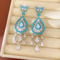 Dettaglio orecchini a farfalla in zircone blu su vassoio espositivo in velluto beige. - Farfalla Goccia d'acqua