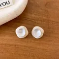 Close-up of sweet irregular dripping oil stud earrings on a warm wooden background - Irregular Stud Earrings / Beige