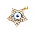 Close-up of a gold star evil eye pendant with blue resin center and cubic zirconia stones - White